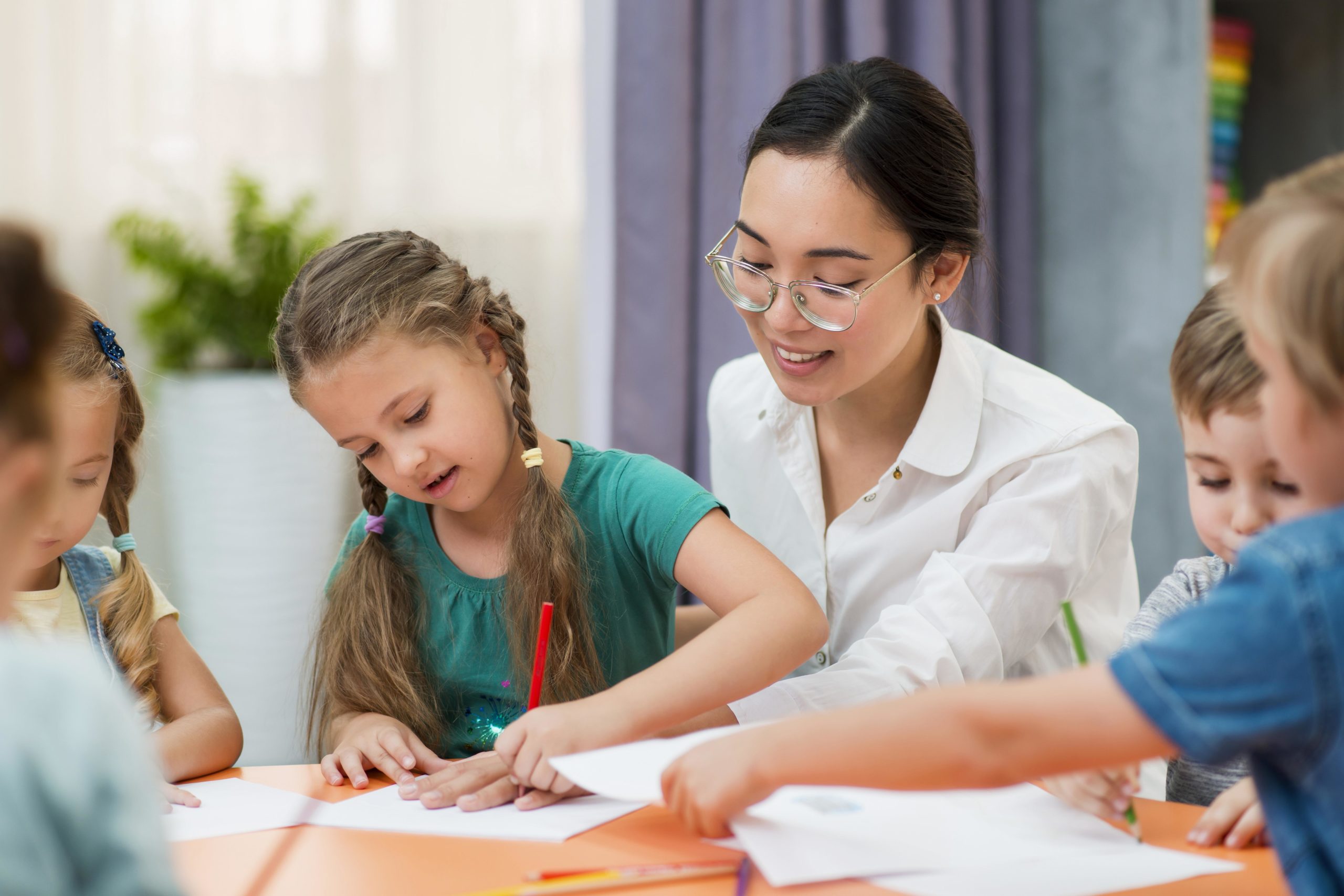 young-teacher-helping-her-students-class